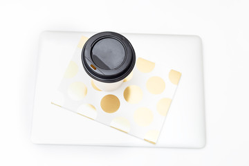 Obraz na płótnie Canvas Paper cup with coffee and a laptop on a white background. Flat lay