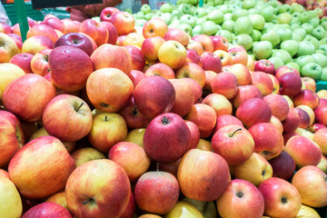 Apples on the market, a large fruit counter, ripe apples red, green
