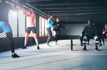 Group of active friends doing crossfit exercises