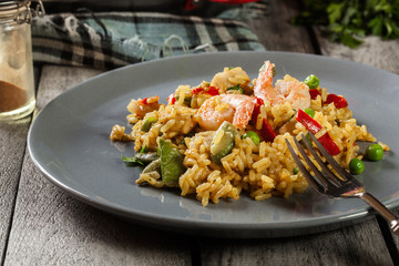 Traditional seafood paella with shrimp, fish and chicken seved in plate.