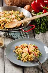Traditional seafood paella with shrimp, fish and chicken seved in plate.
