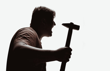 An aggressive man attacks with a hammer. Assault with a hammer. Hand with a hammer. Murder with a...