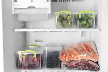 Plastic containers with products in freezer, closeup