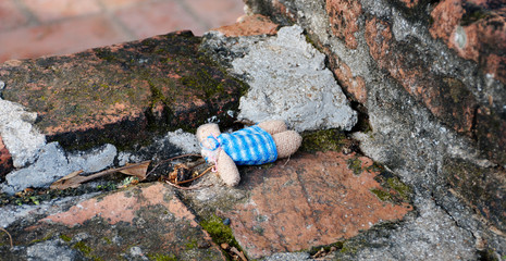 Obraz premium An abandoned headless doll laying on the bricked floor.