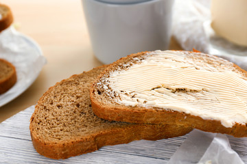 Slices of tasty bread and butter on table, closeup