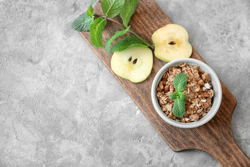 Ramekin with apple crisp on wooden board, top view