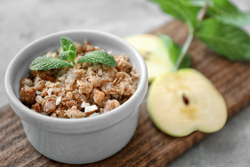 Ramekin with apple crisp on wooden board, closeup