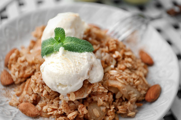 Plate with apple crisp and ice cream on table, closeup
