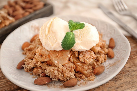Plate with apple crisp and ice cream on table, closeup