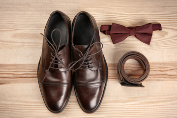 Fototapeta na wymiar Composition with elegant leather men's shoes on wooden background