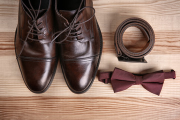Composition with elegant leather men's shoes on wooden background