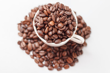Coffee beans in coffee cup on white background