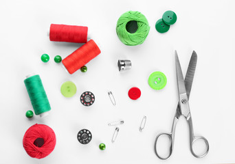 Composition with sewing threads and accessories on white background, top view