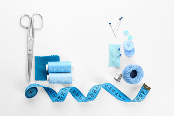 Composition with sewing threads and accessories on white background, top view