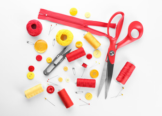 Composition with sewing threads and accessories on white background, top view
