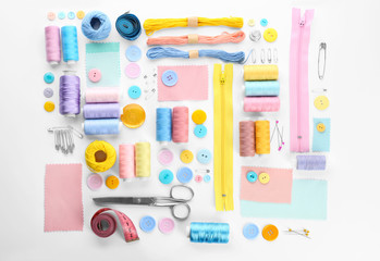 Composition with sewing threads and accessories on white background, top view