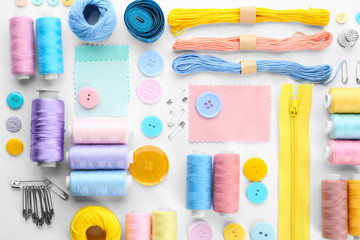 Composition with sewing threads and accessories on white background, top view