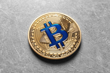 Golden bitcoin on grey background
