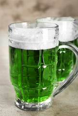 Glasses of green beer on grey background. Saint Patrick's day celebration