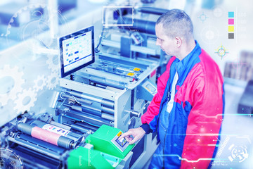Worker next to the flexographic printing machine inputs the data by pressing the touch screen. Skilled printing operator controls printing machine via the touch screen. Rotary printing press.