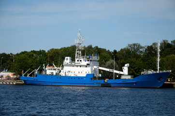 A blue ship moored on the port quay - obrazy, fototapety, plakaty