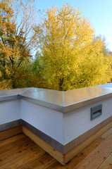 View from the terraces at the autumn landscape of the forest. The terrace wall is bent incorrectly. The forest in the background is in autumn colors. The wild and urban environment is visible. 