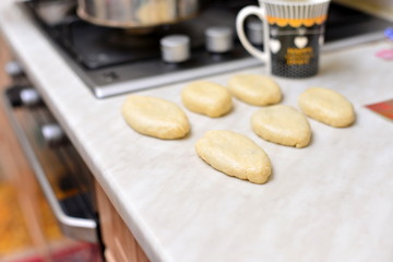 The hands of an elderly woman prepare a pie of thin fresh dough with stuffed minced meat and spicy seasonings