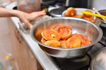 The hands of an elderly woman prepare a pie of thin fresh dough with stuffed minced meat and spicy seasonings