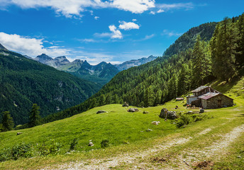Fototapeta na wymiar Mountain stone house and gorgeous mountainscape in North Italy