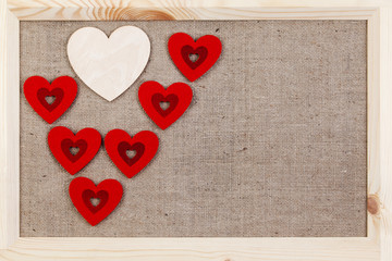 Heart on a wooden background covered with burlap, a card for Valentine's Day.