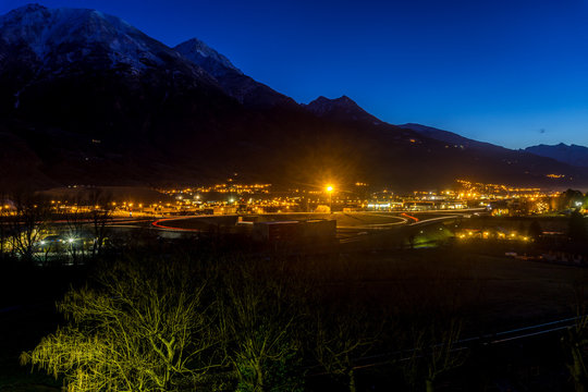 Italian city at blue hour with mountains on background