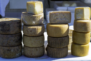 forms of pecorino cheese arranged for sale in an agricultural market in southern Italy