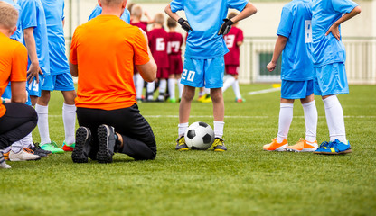 Obraz premium Boys With Football Coach Having Pep Talk Before Youth Sports Tournament Competition