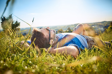 Man lying in grass on hiking trip in the mountains