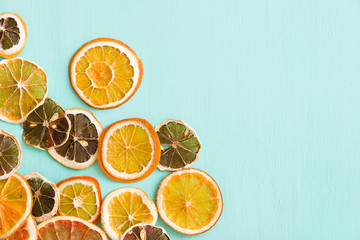 Top view on dried citrus slices: grapefruit, orange and lemon on turquoise background