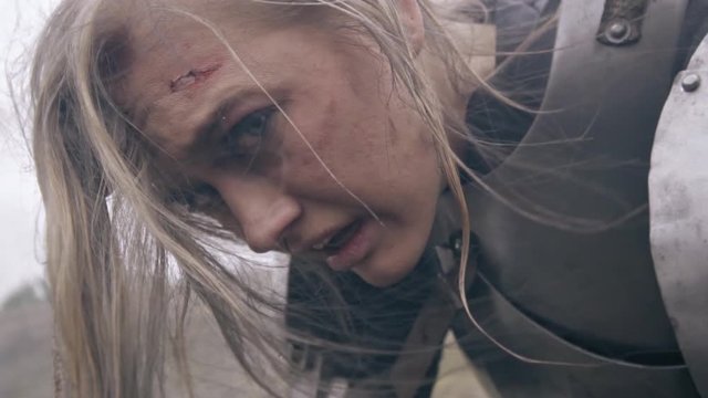 Snotty and wounded woman knight turns her head at the camera, slow motion