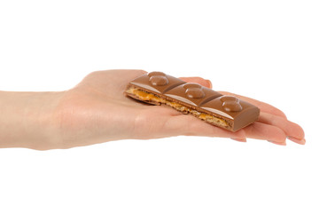 Chocolate with caramel and nuts in hand