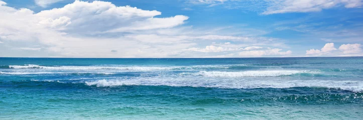 Deurstickers Kust Zee golven en blauwe lucht.