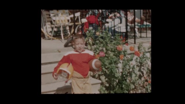 1958 6 year old boy in football uniform straps on football helmet