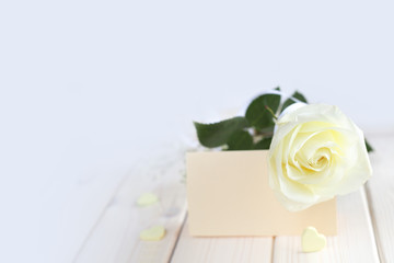 Obraz na płótnie Canvas Rose, hearts and card on table
