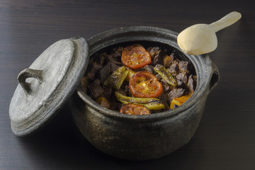 Eintopf im Tontopf mit Holzl&ouml;ffel und Deckel