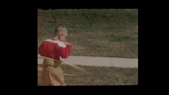 Boy in football uniform does Hula Hoop