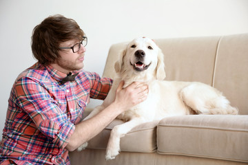 Handsome young hipster with dog at home