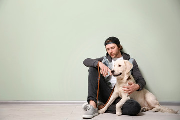 Handsome young hipster with dog indoors