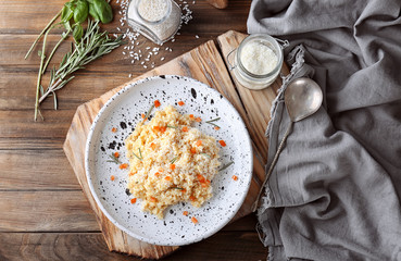 Plate with delicious risotto on wooden table