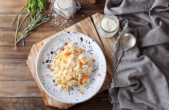 Plate with delicious risotto on wooden table