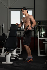 Fototapeta na wymiar Bodybuilder Exercising Shoulder With Dumbbell