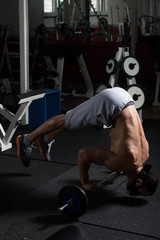 Bodybuilder Exercising Push-Ups On Barbell In Elevation Mask