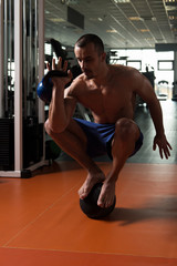 Man Doing Kettle Bell Exercise On Medicine Ball