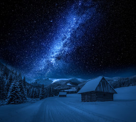 Naklejka premium Milky way, cottages and snowy road at night, Tatra Mountains